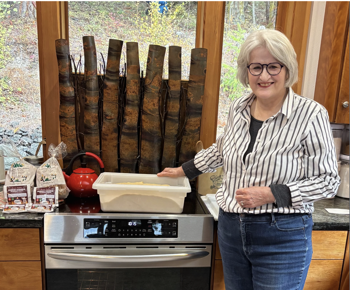 Jane Hutcheson, stands next to bread dough proofing on top of her oven